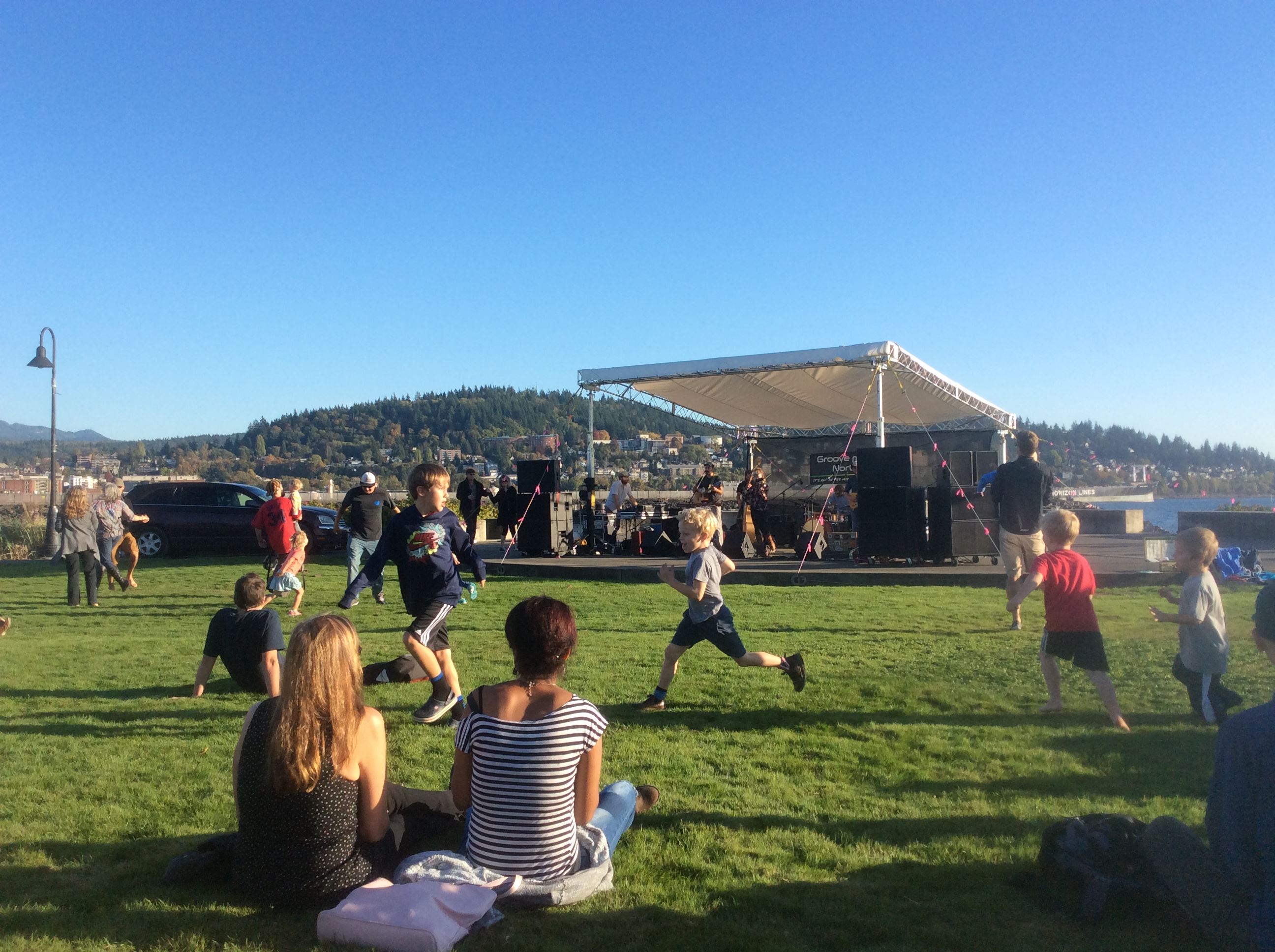 Tom Glenn Common stage set up by the bay with children running and people watching music