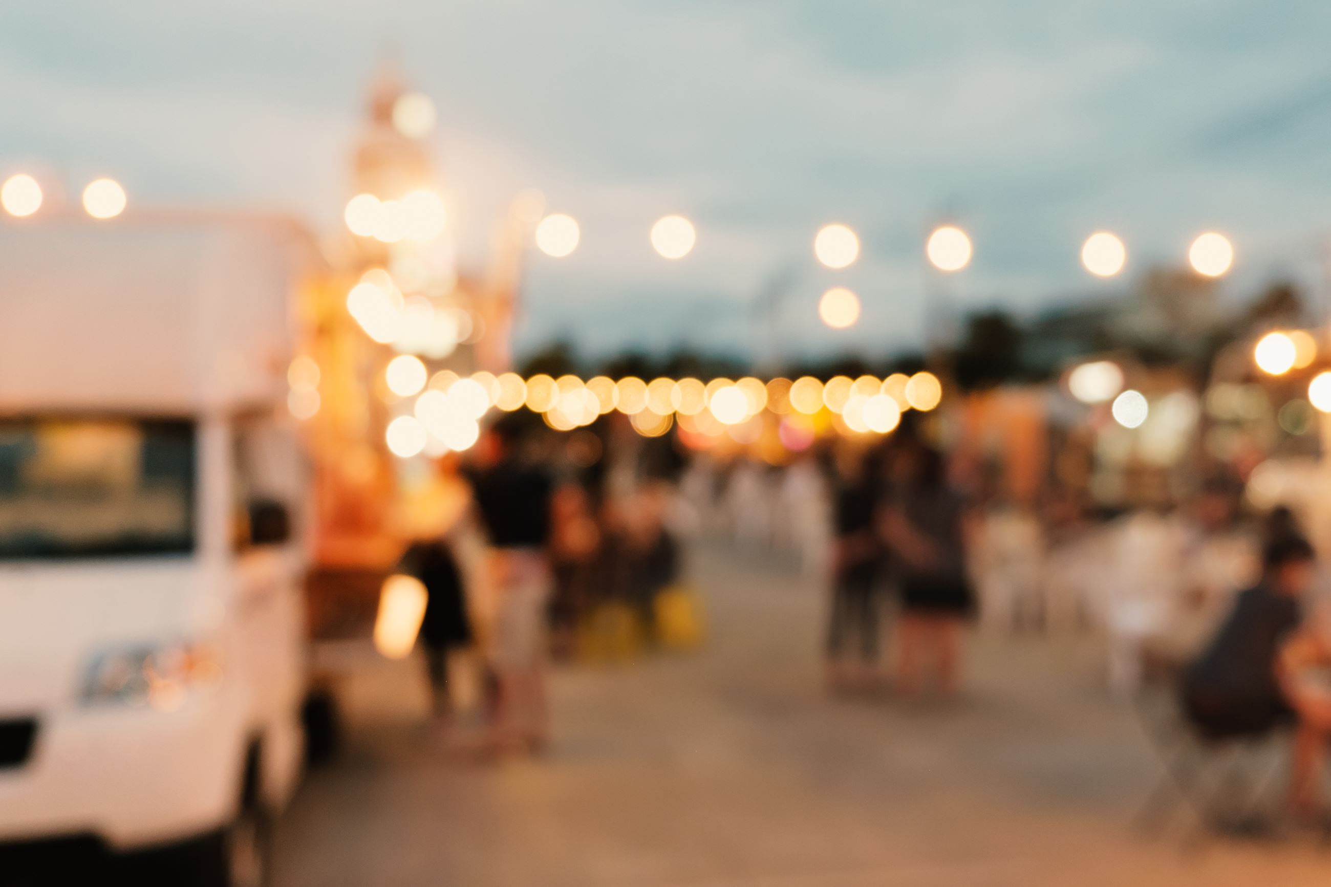 Food Truck in background with tables and bistro lights strung above